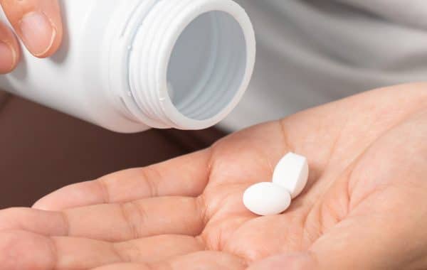 white tablets on woman's hand