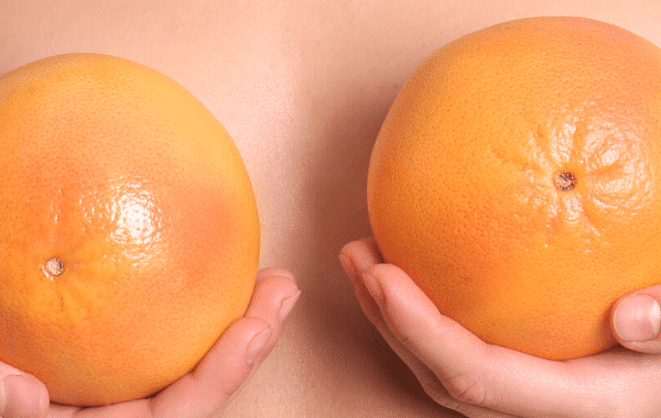 woman holding two oranges