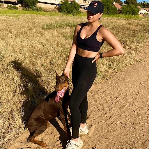 woman in active wear with her dog in hand