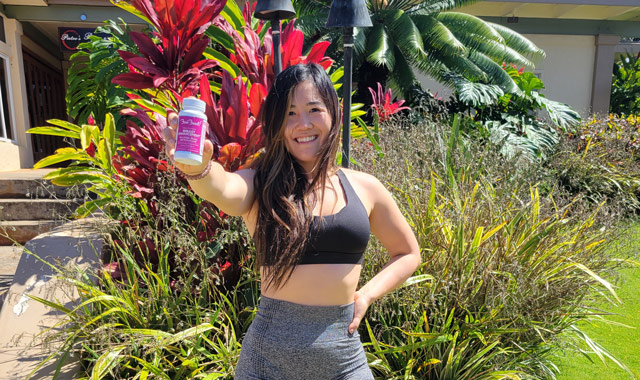 cheerful woman holding a supplement bottle