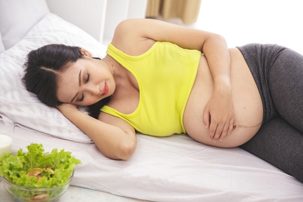 pregnant woman lying on a bed