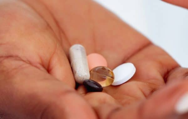 african woman hand holding pills