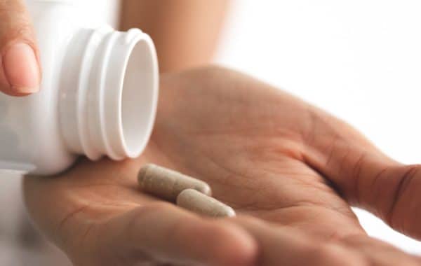 woman holding supplement capsules