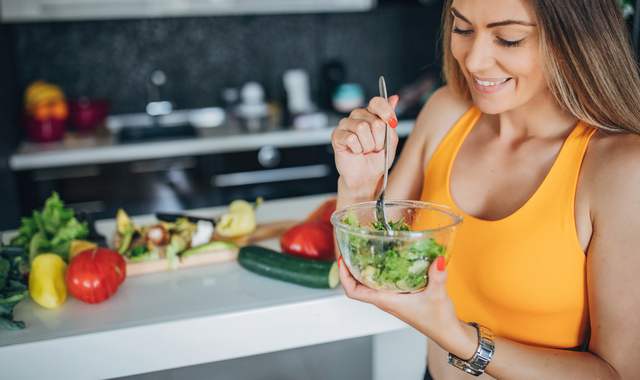 one fit woman eating healthy vegetable salad for breakfast