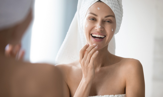 woman enjoying morning skincare routine in bathroom