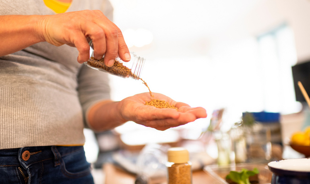 woman pours fenugreek seeds into hand for sprouting