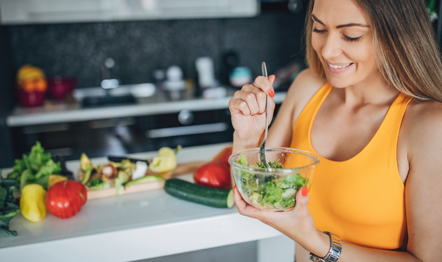 one fit woman eating healthy vegetable salad