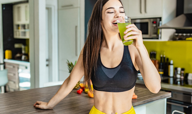 woman drinking green juice