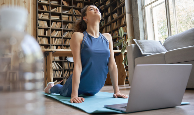 woman doing online yoga exercise at home