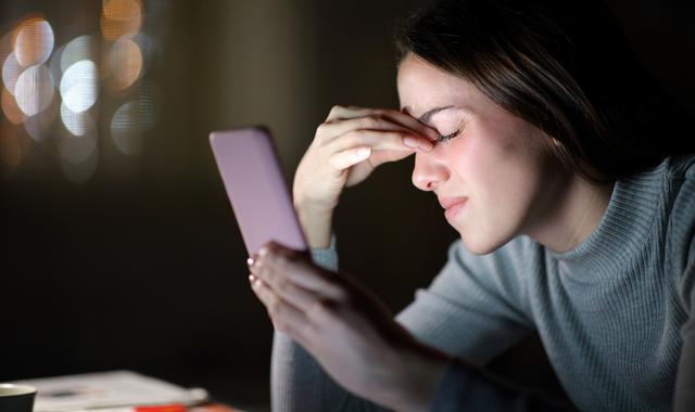tired woman suffering eyestrain using phone in the night