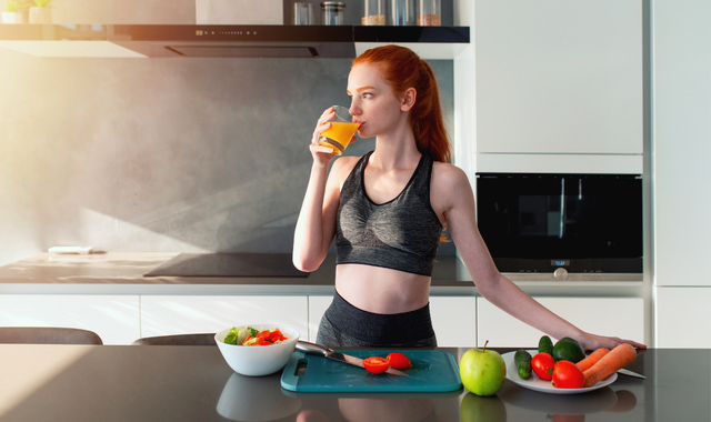 young woman drinking a glass of orange juice