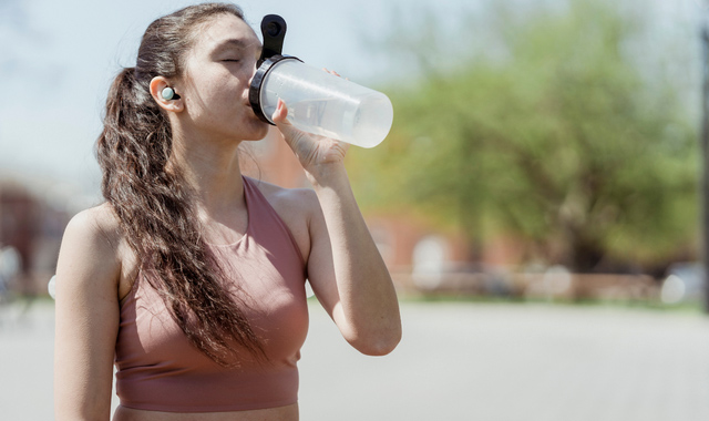 woman in sportswear drinking water from bottle