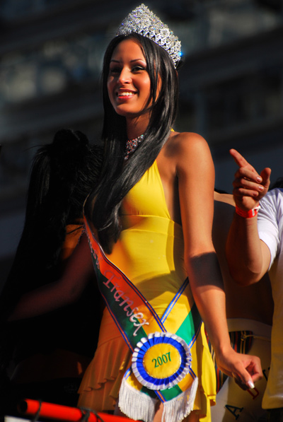 trans woman wearing a pageant sash at a pride parade