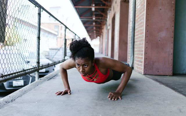 woman in red sports bra doing push-ups