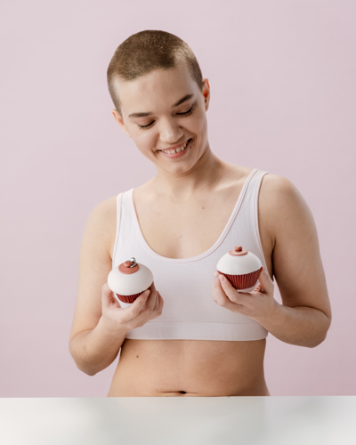 woman in white tank top holding cupcakes