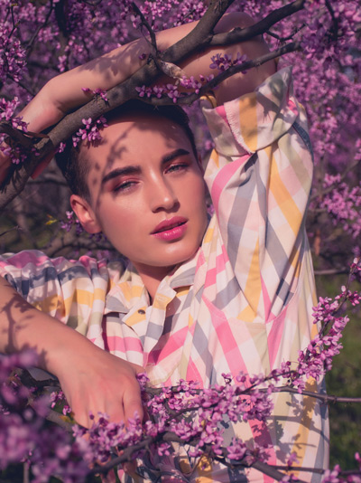 MTF woman standing amongst purple flowers