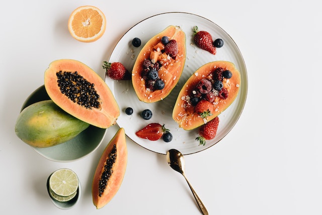 sliced papaya with berries on top