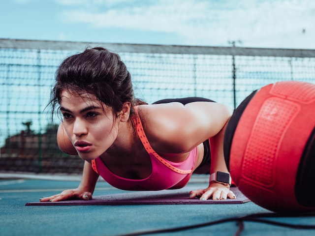 woman exercising next to a ball